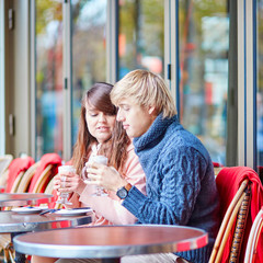 Happy young couple drinking coffee in cafe