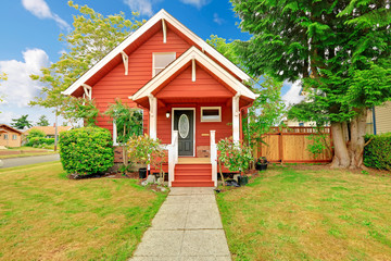Small coutnryside house exterior in bright red color with white