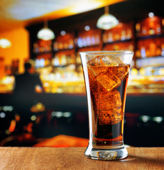 Glass of cola with ice in a bar