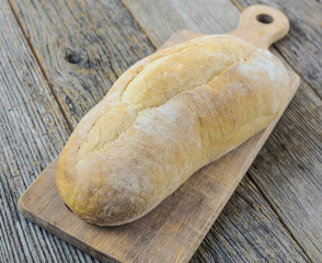 Bread on a Bread Board with Rustic Wood Background