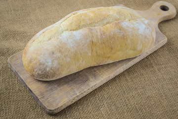 Bread on Bread Board on Burlap Background