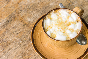 Orange coffee cup on wooden table background