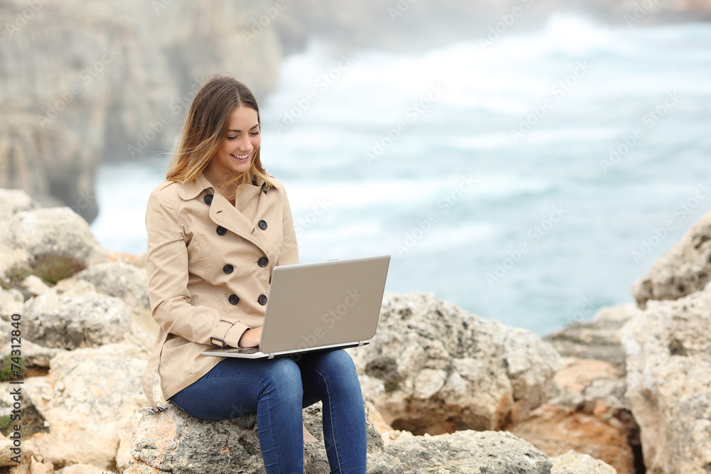 Sticker beautiful woman browsing her laptop in winter on the coast