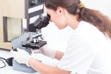 female student looking into the microscope