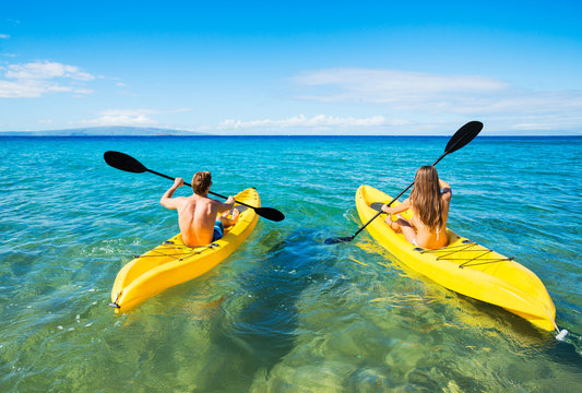 Man And Woman Kayaking In The Ocean