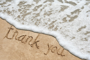 Fototapeta premium Conceptual thank you text in sand and water