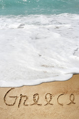 Conceptual Greece text in sand and water
