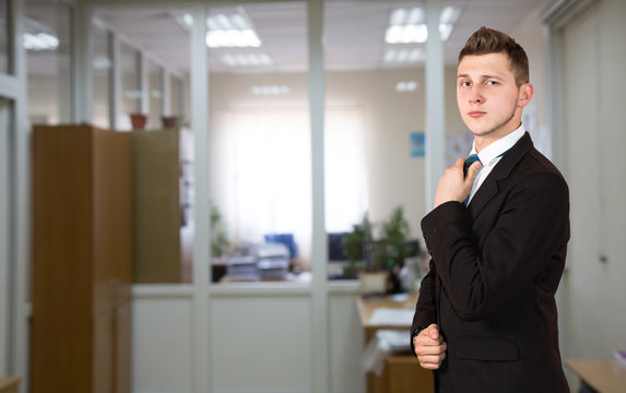 Funny young male businessman inside office background