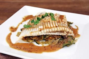 rochenflügel mit zucchini und zwiebelgemüse