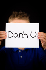 Child holding sign with Dutch words Dank U - Thank You