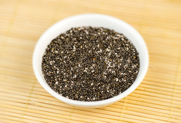 Aerial closeup of chia seeds in white bowl