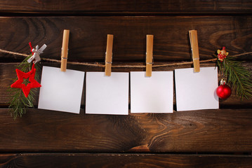 blank paper cards hanging on rope against wooden background