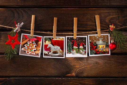 christmas photos hanging on rope against wooden background