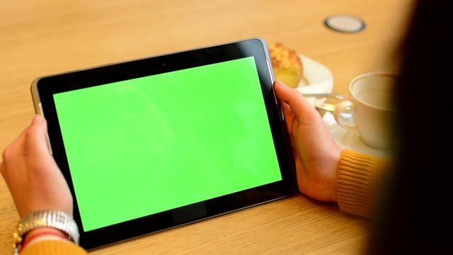 woman works on tablet green screen in cafe - coffee and cake