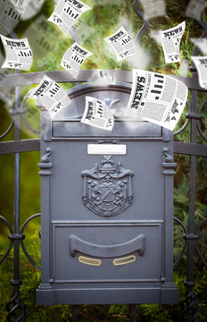 Post box with daily newspapers flying