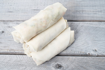Uncooked Vietnamese egg rolls, Cha Gio,  on a wooden table