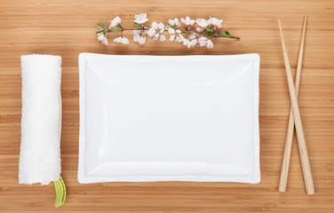 Empty plate, chopsticks and sakura branch