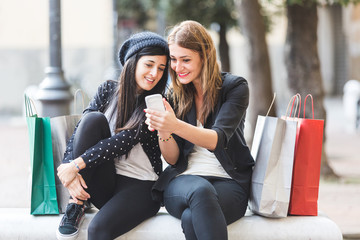 Happy Women with Smart Phone and Shopping Bags