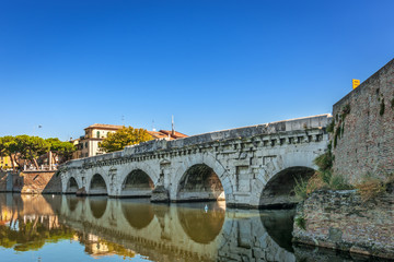 Fototapeta premium Historical roman Tiberius bridge over Marecchia river in Rimini