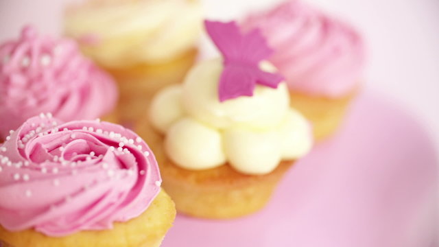 Closeup pan of beautifully decorated pink and white cupcakes