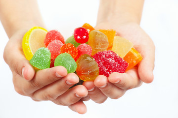 Child hands with colorful sweetmeats and jelly closeup