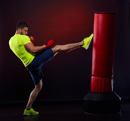 young man exercising bag boxing in studio