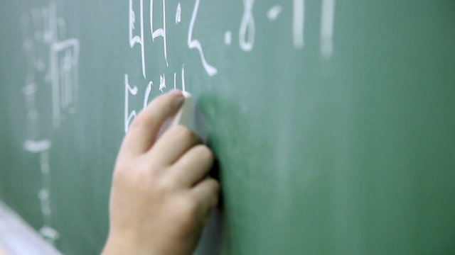 little boy solves math on the blackboard at school 5