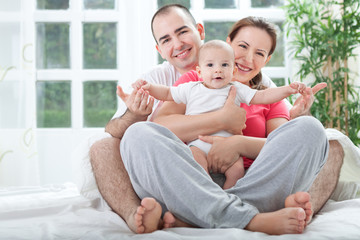 Obraz premium Happy family at home in bed
