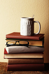 Old books and cup of coffee on table