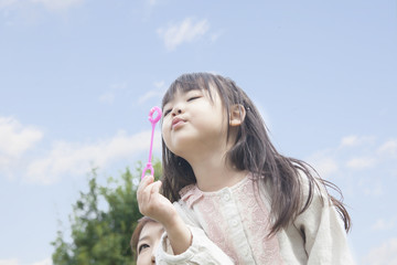 シャボン玉で遊ぶ子供