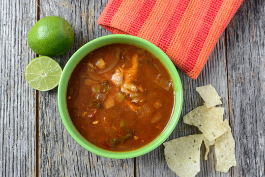 Tortilla Soup with Chips and fresh lime on Rustic Wood Backgroun
