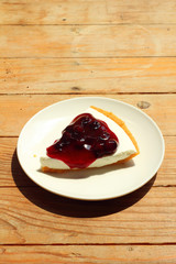 close up blue berry cheese cake in white dish