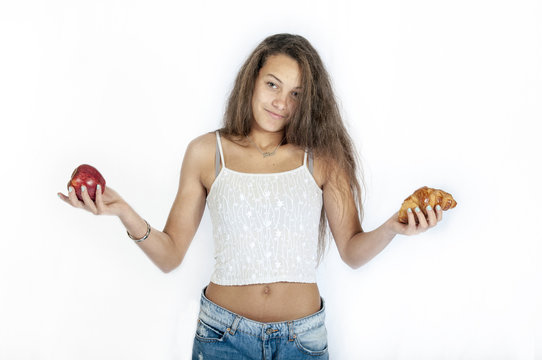 Jeune fille h&eacute;sitant entre pomme ou croissant