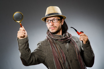 Funny detective with smoking pipe and magnifying glass