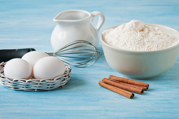 Ingredients and tools to make a cake, meal, eggs and cinnamon