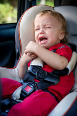 crying baby boy in car seat