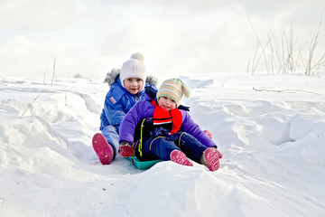 Fototapeta na wymiar Two girls on sled in winter
