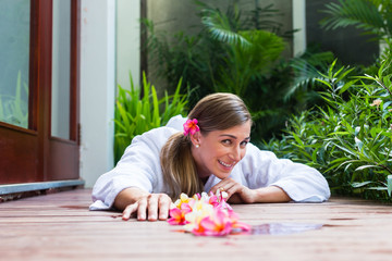 Obraz na płótnie Canvas Woman with flowers at tropical pool