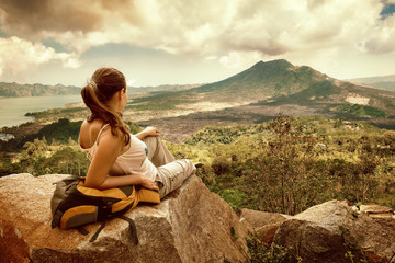 Naklejka na ściany i meble Woman traveler looking at Batur volcano