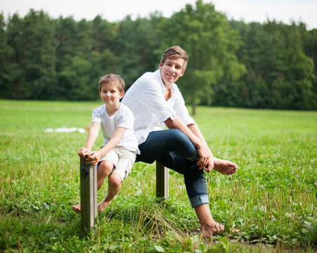 Vater und Sohn sitzen auf Pfosten im park