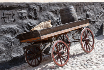 Fototapeta na wymiar old wooden cart on background of brick wall