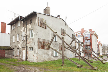 Wooden construction preventing building wall from collapsing.
