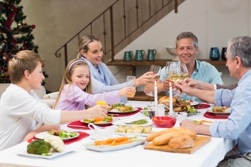 Fototapeta na wymiar Family toasting with white wine in a christmas dinner