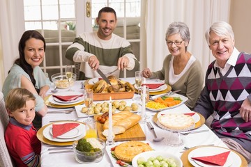Man carving roast turkey during christmas dinner
