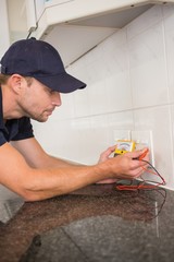 Electrician metering voltage with digital multimeter