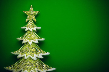 golden christmas tree on green paper background