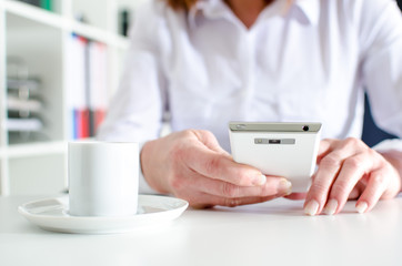 Businesswoman using a smartphone during coffee break