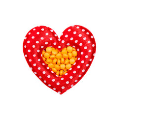 pills in red heart shaped box isolated on white background