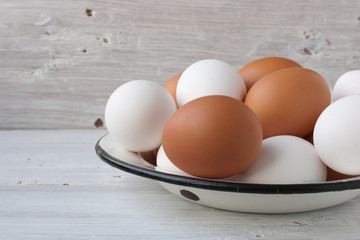 Chicken eggs in a metall dish on the white boards