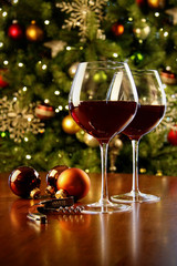 Glasses of red wine on table with Christmas tree - 74390688